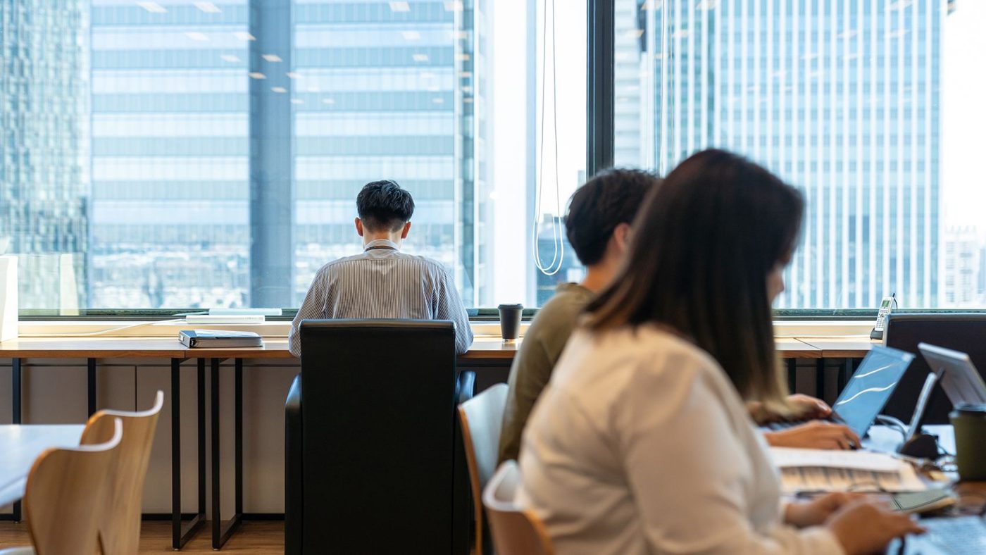 窓際の席で働く社員