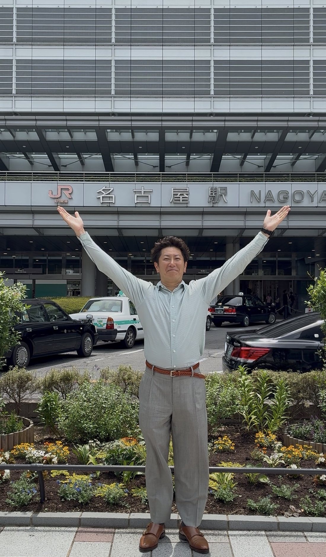 名古屋駅の前で両手を広げるかとう社長